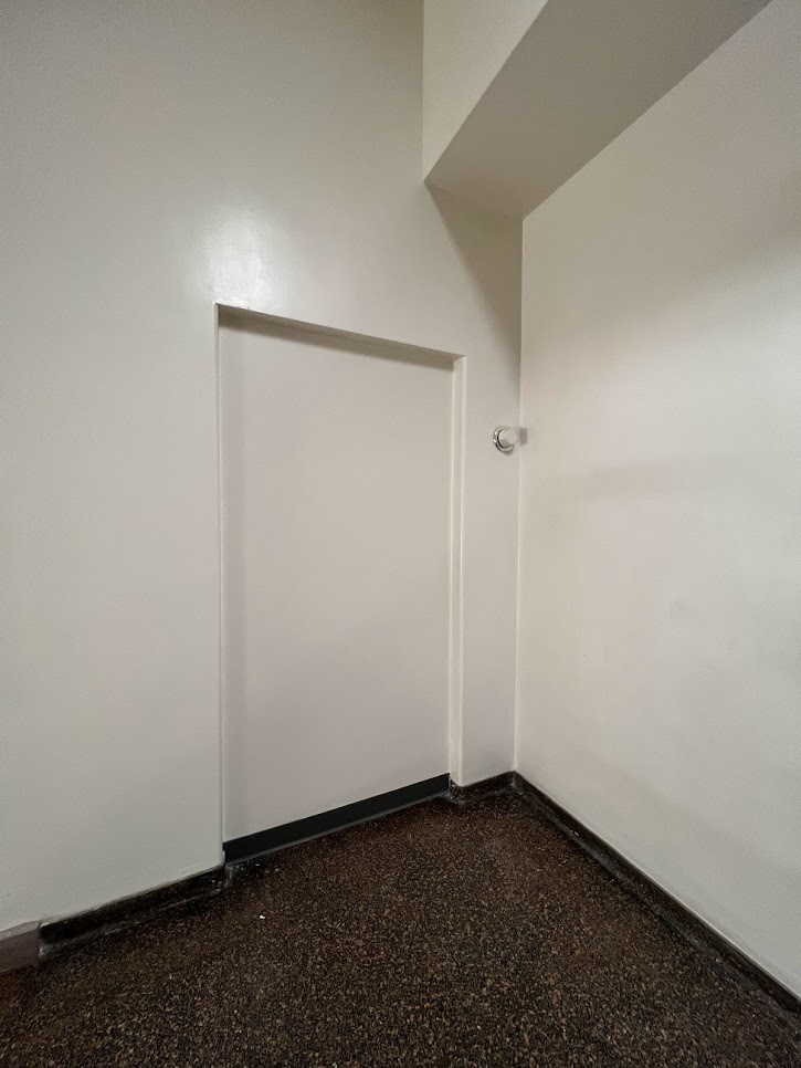 missing door in a plain white hall